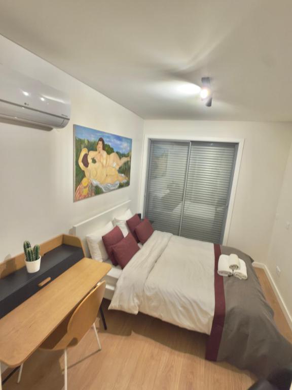 a bedroom with a bed and a desk and a table at Suíte aconchegante in Lisbon