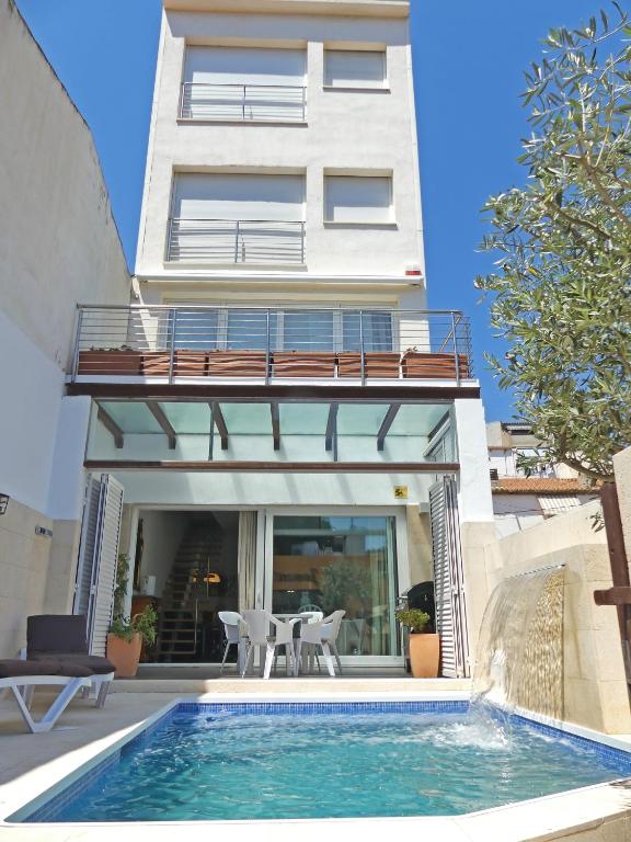 a house with a swimming pool in front of a building at VILLA MON REPOS CON PISCINA Y A/A in Colera