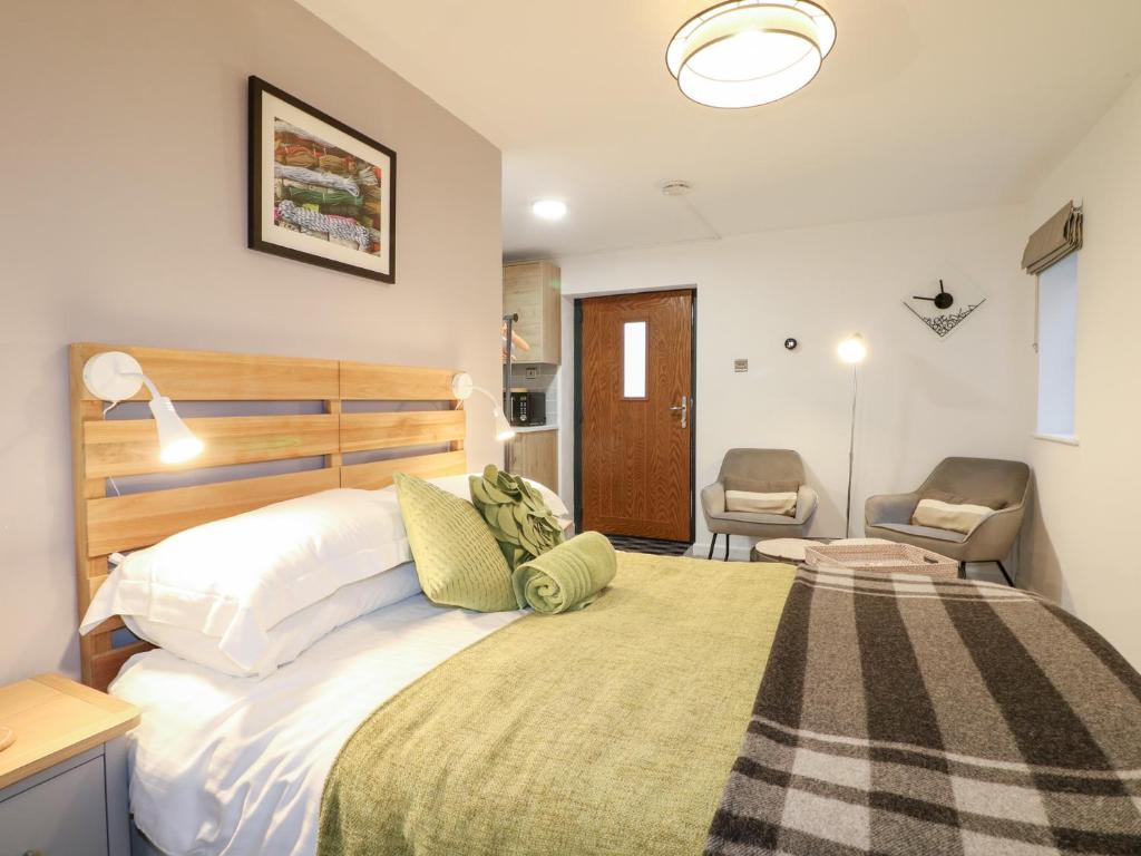 a bedroom with a large bed and a chair at The BullpenManor Farm in Salisbury