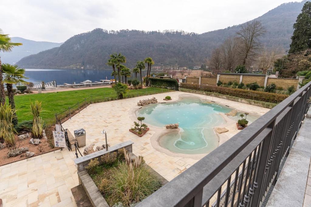 a swimming pool with a view of a lake at Elegant Lake View Apartment with Pool in Lavena Ponte Tresa