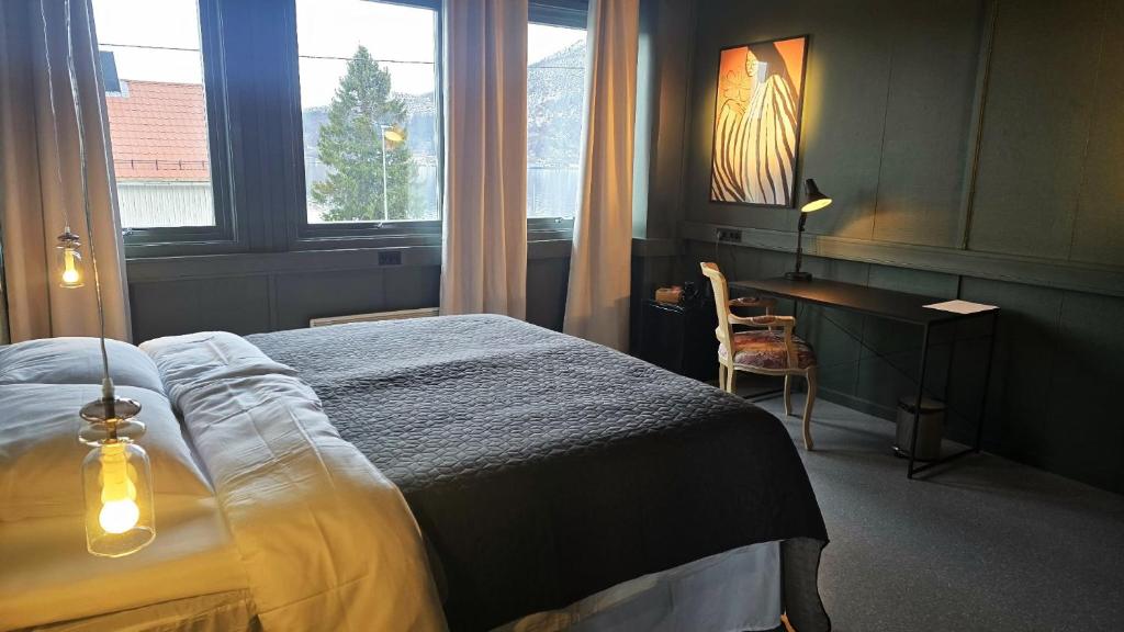 a bedroom with a bed and a desk and a window at Kuben Utleie in Narvik