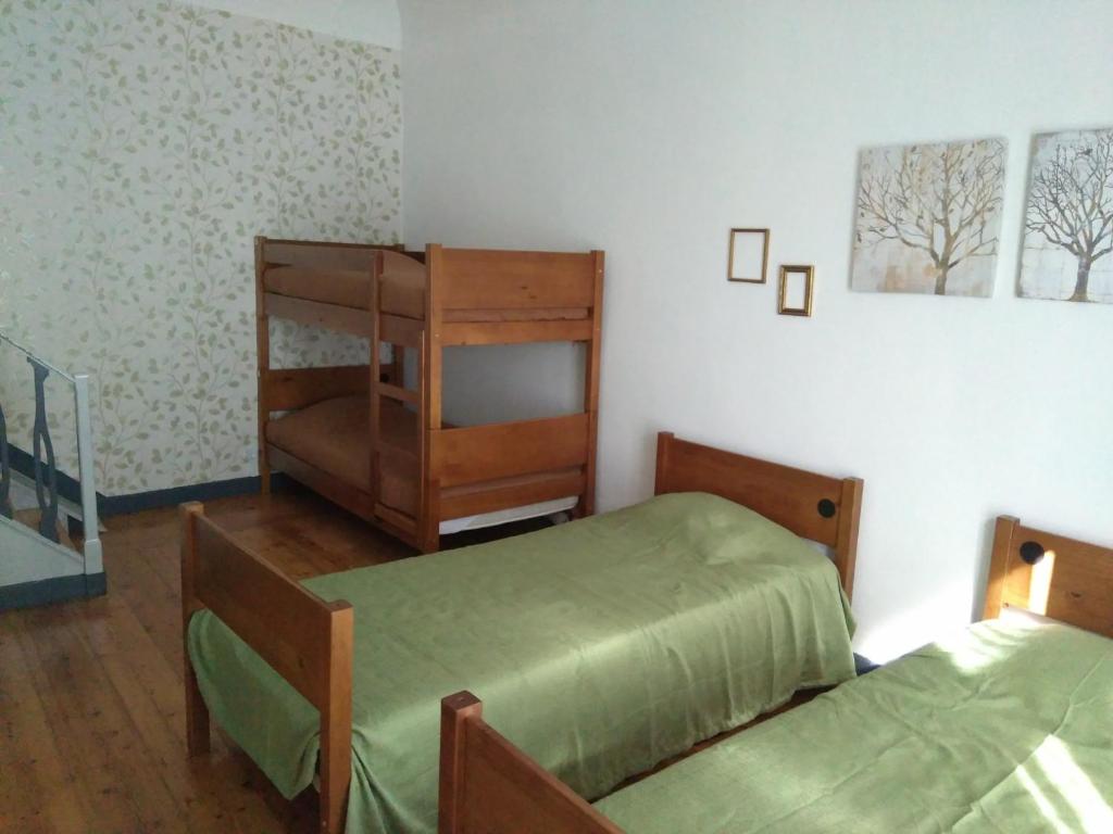 a bedroom with two beds and a book shelf at Hostel Raymundo in Évora