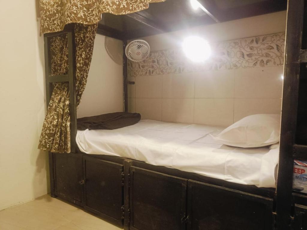 a bedroom with a bunk bed with white sheets at Farhan DORMITORY in Mumbai