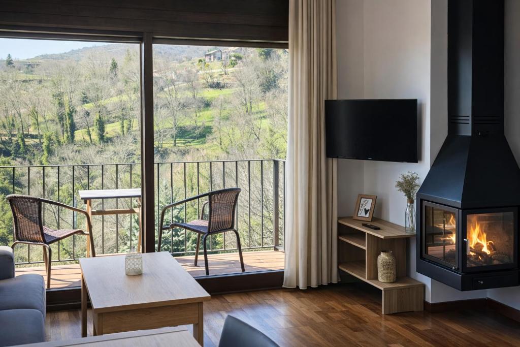 a living room with a fireplace and a balcony at Allotjaments Pirineus in Molló