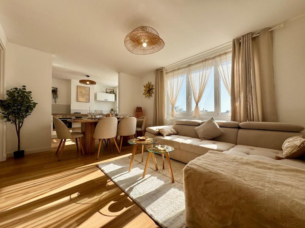 a living room with a couch and a table at Le Nid Doré in Calais