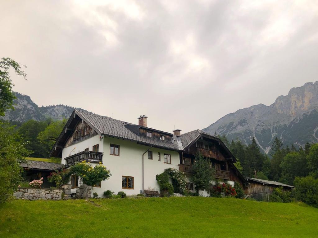a house in a field with mountains in the background at Nusshof in Berchtesgaden