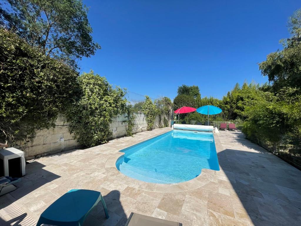 a swimming pool with a red and blue umbrella at La mare aux bambous in Couffy