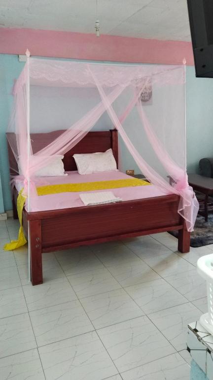a bed with a canopy in a room at royal care villas in Thika