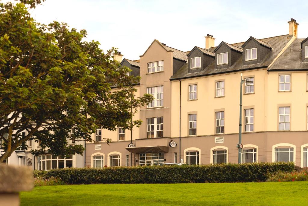 a large building with a green lawn in front of it at Portrush Atlantic Hotel in Portrush
