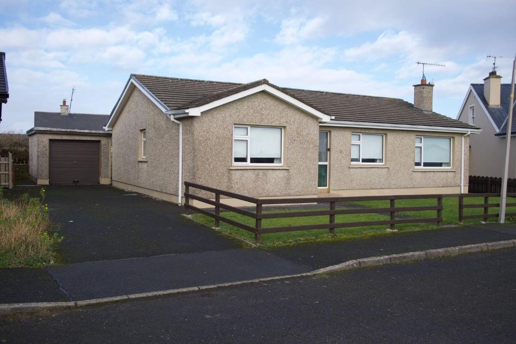 a house with a fence in front of it at Avalon in Bundoran