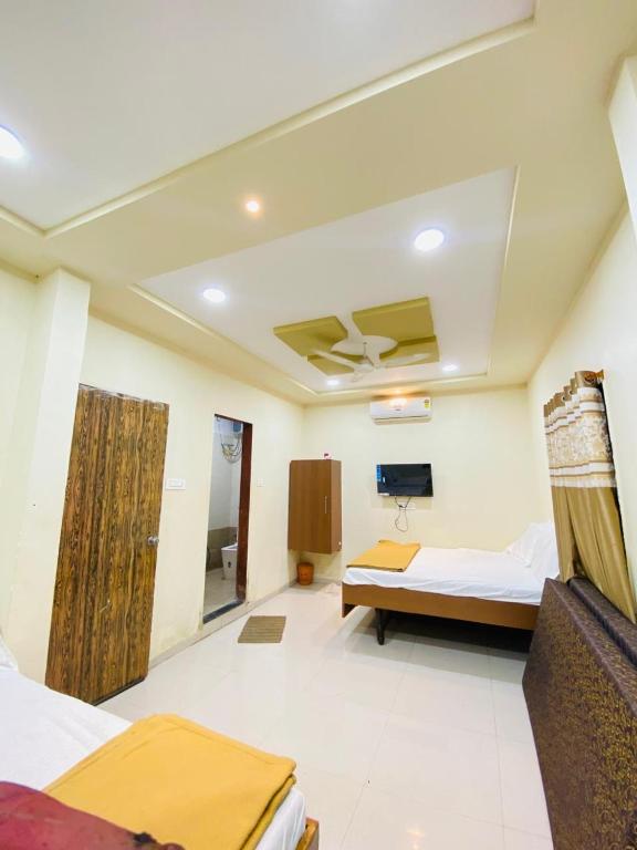 a room with two beds and a tv on the ceiling at Vishwa Heritage Ellora in Ellora
