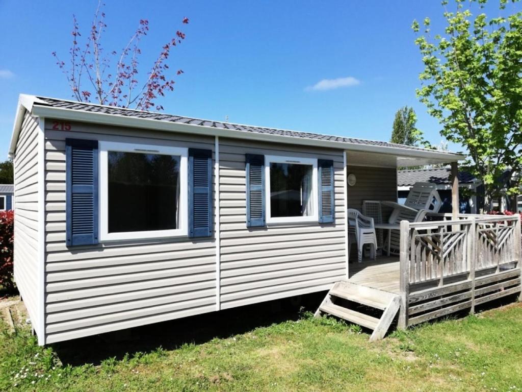 a white and blue tiny house with a porch at Camping Le Bois Soleil - Mobil home 3 pièces 4 personnes + TV MAE-4364 in Les Sables-d'Olonne