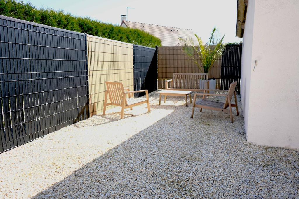 eine Terrasse mit zwei Stühlen, einem Tisch und Bänken in der Unterkunft Zénithouse in Éterville