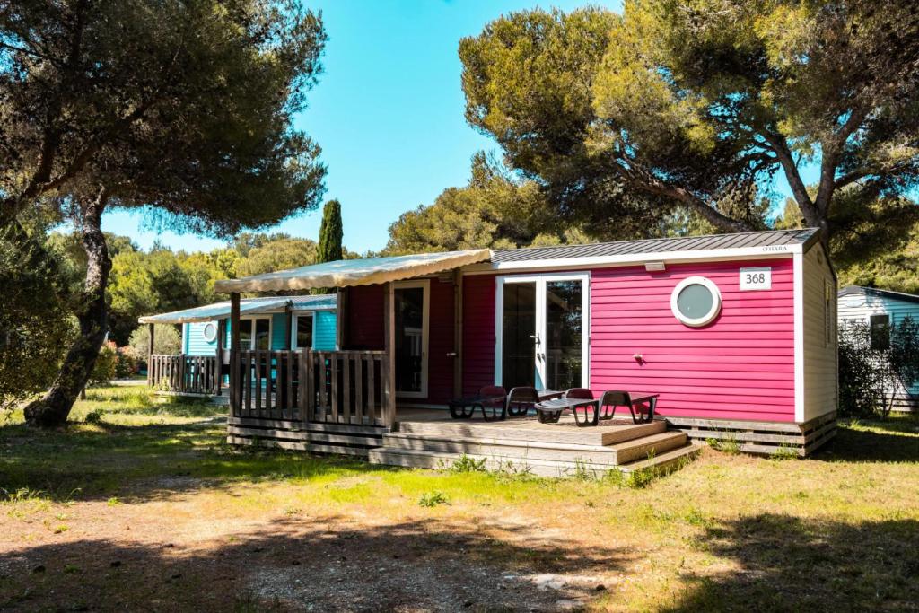 a small pink house with a porch at Camping l'Arquet - Mobil-home Premium 4 pièces 6 personnes climatisé MAE-3771 in Martigues