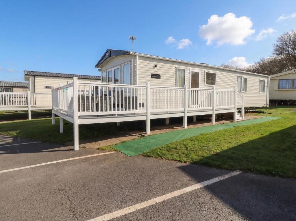 a mobile home with a porch and a deck at Cresswell Towers in Morpeth