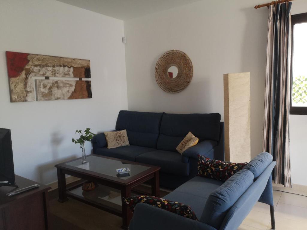 a living room with a blue couch and a table at Sunhouse in Playa Honda