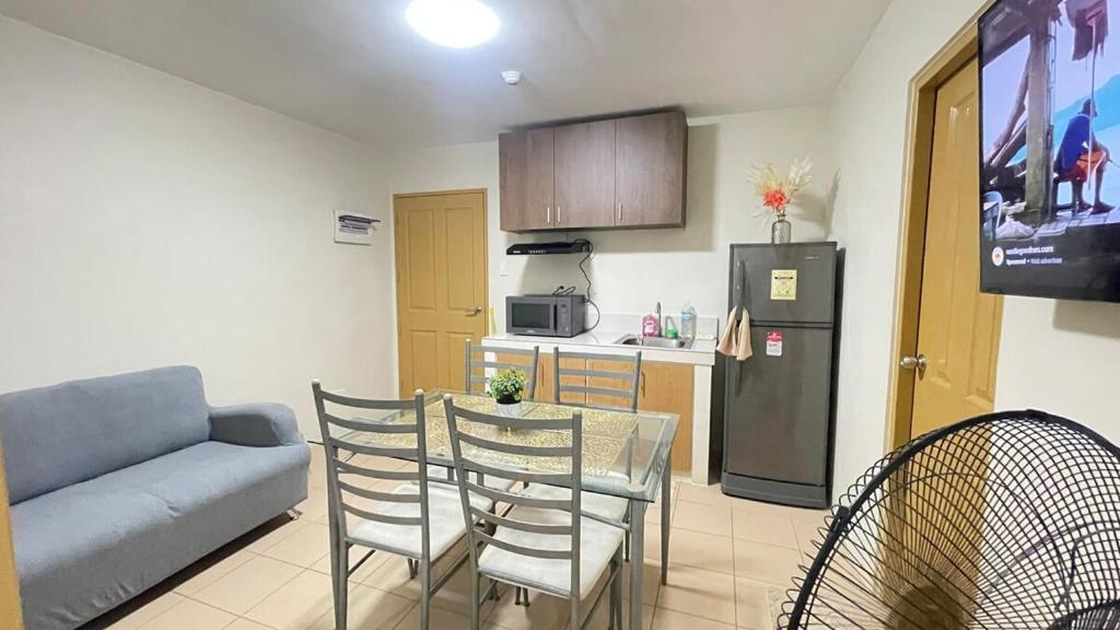 a living room with a table and chairs and a kitchen at Kurt Condo Rental Simple & Cozy in Piapi