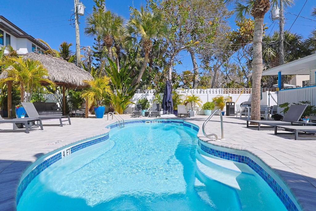 a swimming pool in a resort with palm trees at The Inn on Siesta Key in Siesta Key