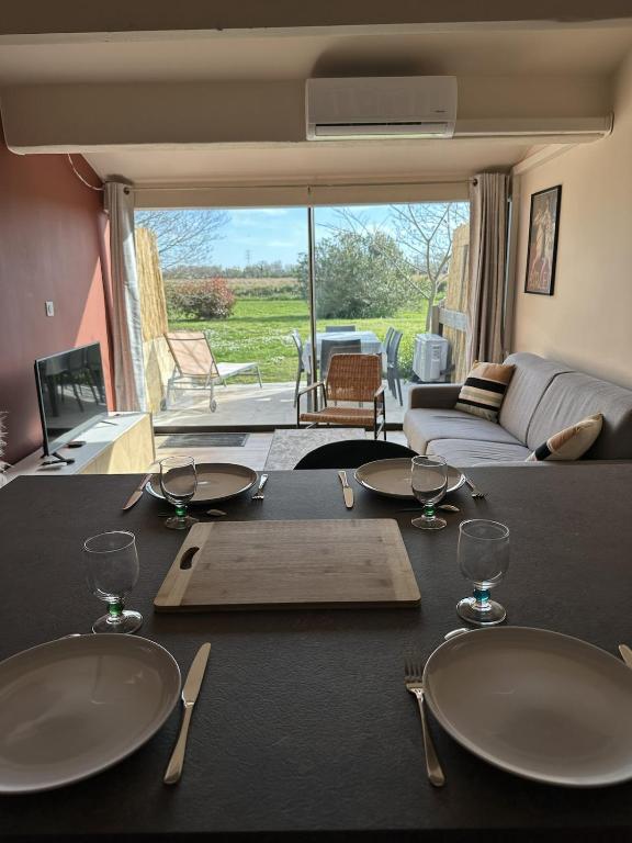 a dining table with two plates and wine glasses at Cozy Duplex in Arles