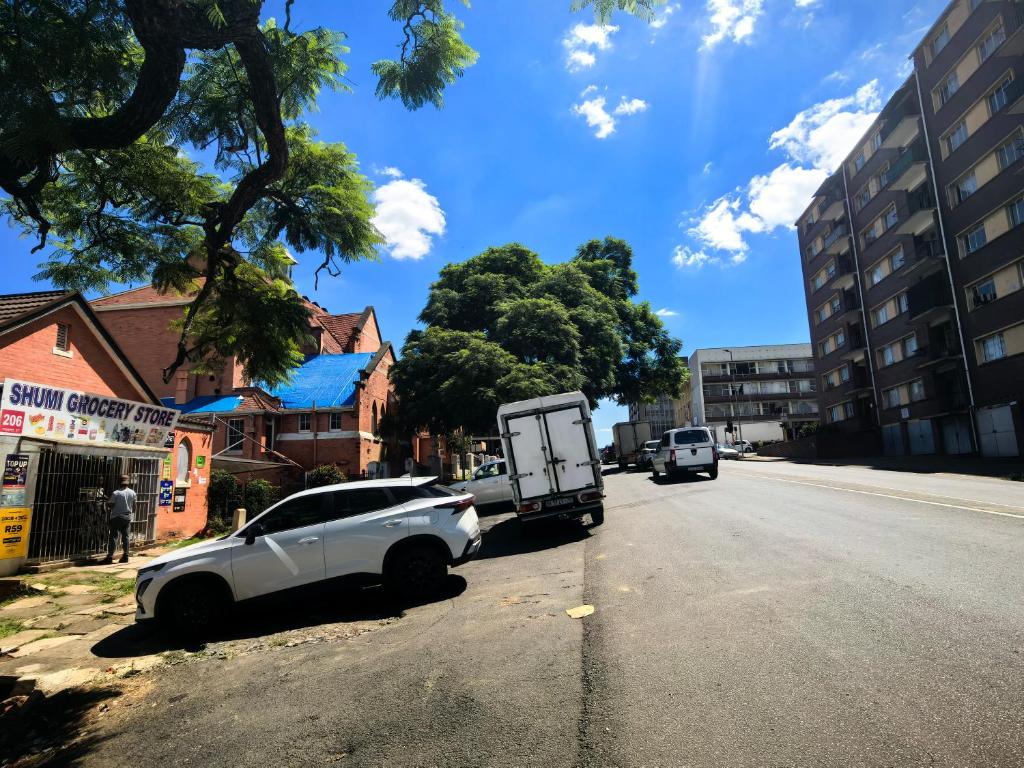a white car parked on the side of a street at S-and Kasa Guest House in Pietermaritzburg