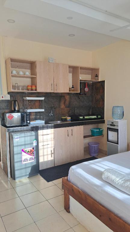 a large kitchen with a bed in a room at Diani Haven Swahili modern studio in Kwale