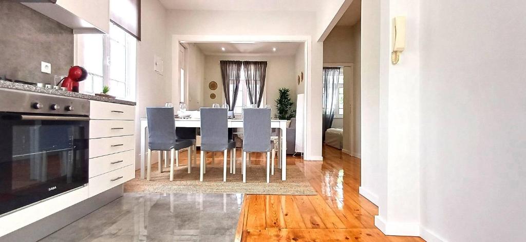 a kitchen and dining room with a table and chairs at 1000Jo Apartment T3 in Gulpilhares