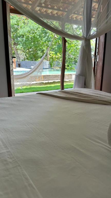 a bedroom with a bed with a canopy at villa coqueiro praia do prea in Cruz
