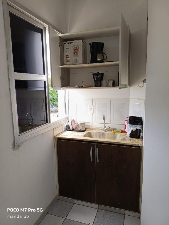 a kitchen with a sink and a window at FARO FINO 203 x in Goiânia