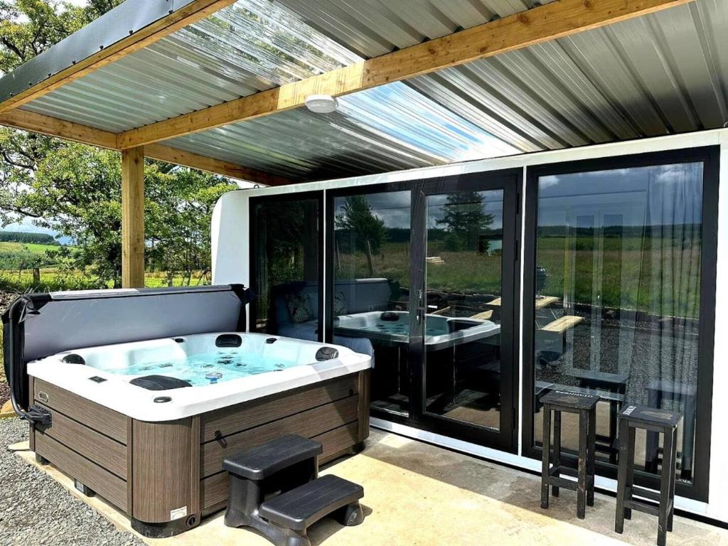a jacuzzi tub on a patio with a table at The Lux Pod in Ballynameen