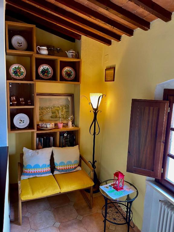 a living room with a yellow couch and a table at Casa Le Campane sulla Via Francigena in Gambassi Terme