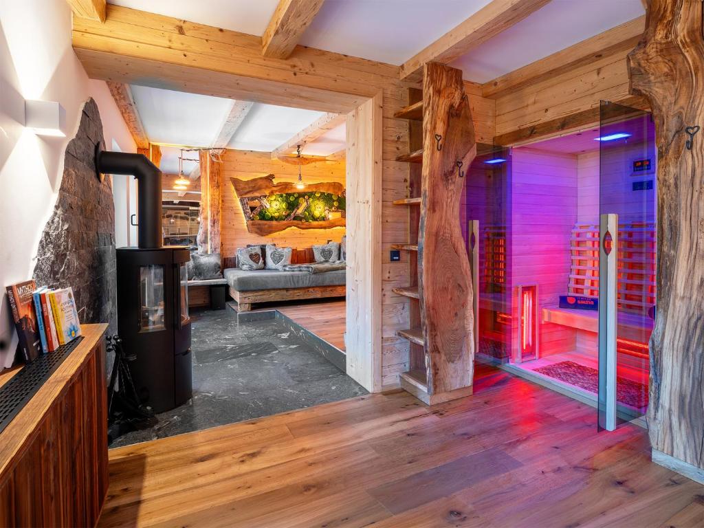 a room with a fireplace in a room with wooden ceilings at Bergromantik Ferienwohnung Harmonie mit Sauna, Whirlpool und Bergblick in Marktschellenberg