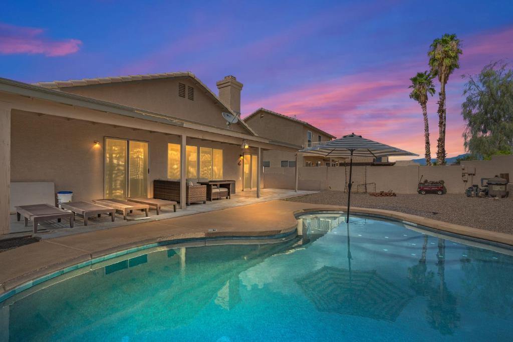 a house with a swimming pool and an umbrella at Private Pool & Fire Pit: Tucson Home Near Hiking! in Tortolita