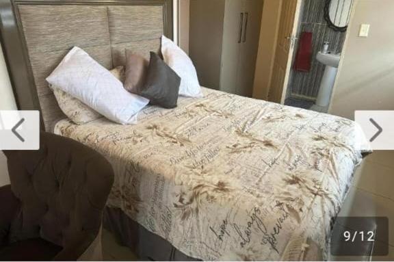 a bed with pillows on it in a room at Lemao guesthouse in Johannesburg