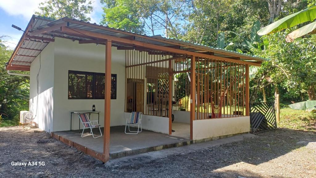 a small house with a porch with two chairs at Donde Dubon Pandi house in Puerto Jiménez