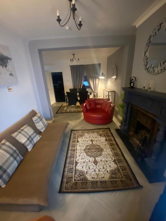 a living room with a red couch and a fireplace at Manor House OVER 25 ONLY kids with adults allowed in Belfast