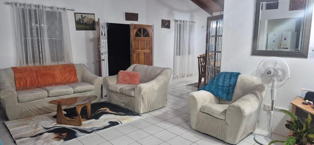 a living room with couches and chairs and a fan at Villas De Morne St Lucia in Grande Rivière