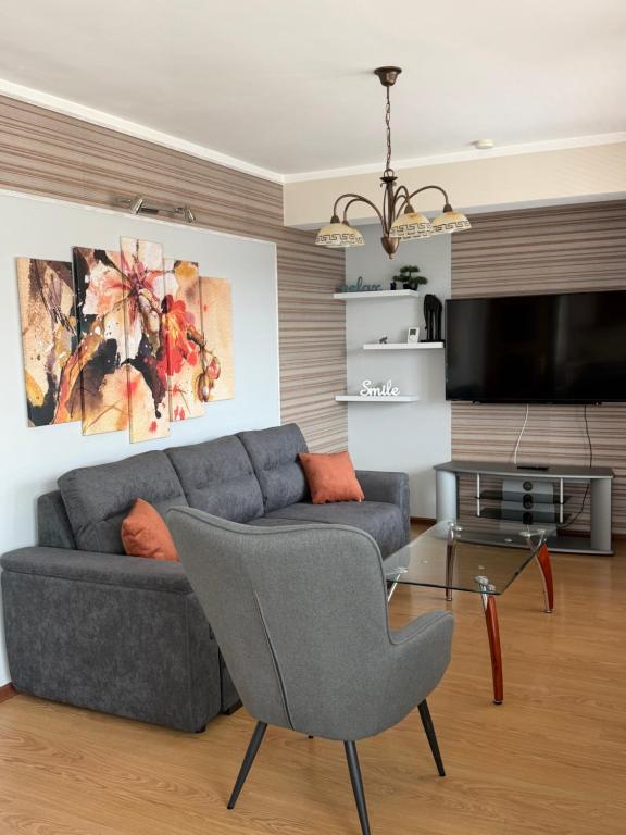 a living room with a couch and a tv at Apartment VEDA - Апартамент ВЕДА in Veliko Tŭrnovo