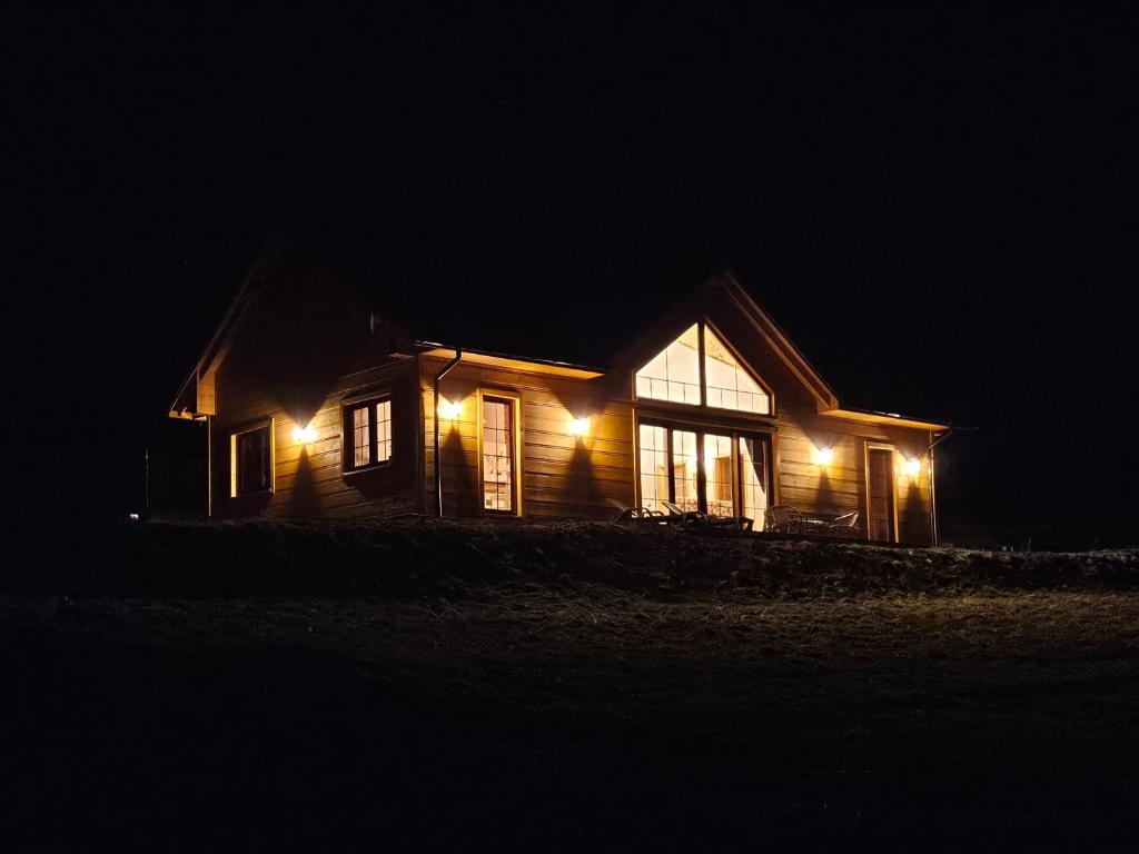 a house with lights on the side of it at night at Dom na słodkim wzgórzu in Trzebinia