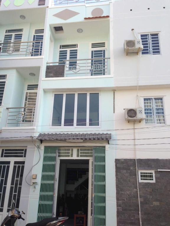 a white apartment building with a door and a building at homestay Huynh DC in Ho Chi Minh City