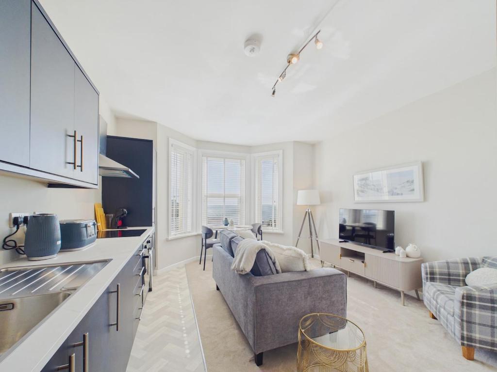 a kitchen and a living room with a couch at Southbourne beach in Southbourne