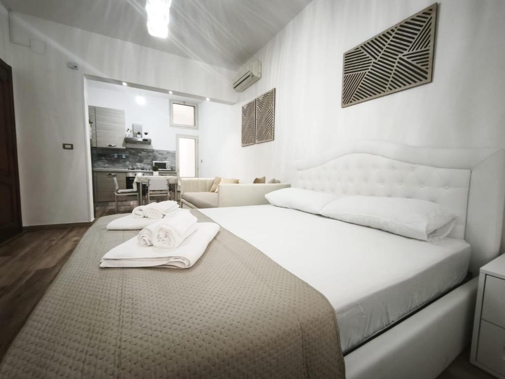 a white bedroom with a large bed with towels on it at B&B Ampelea in Gallipoli