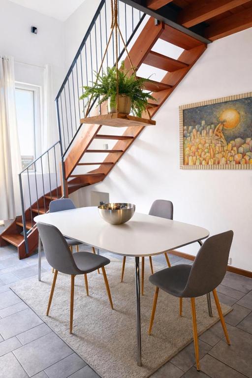 a dining room with a white table and chairs at Casa di Cocco in Alzano Lombardo