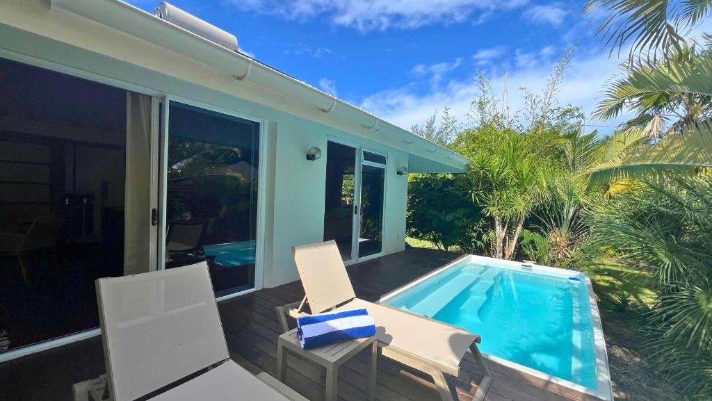a patio with two chairs and a swimming pool at Moorea - Temae Reef Cottage in Temae
