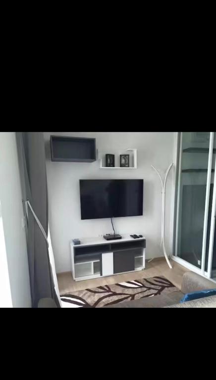 a living room with a flat screen tv and a table at Perfectly Located Airport Link Train City Access in Bangkok