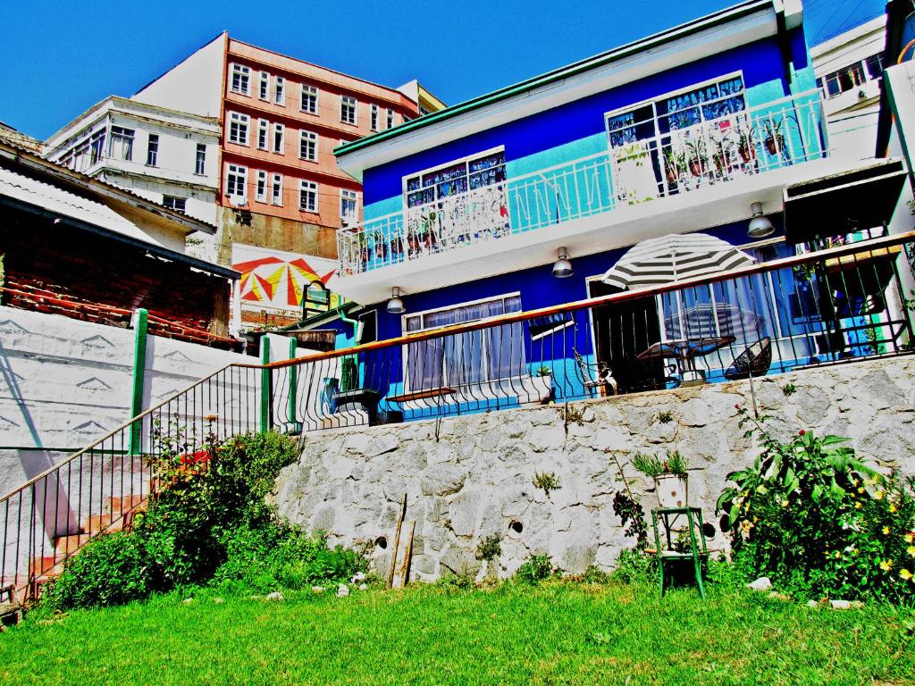 un edificio azul con ventanas y balcones en una calle en La Casa Azul Hostel, en Valparaíso