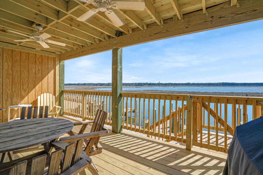 a porch with a table and chairs on a deck at Channel Winds - Waterfront Bliss & Lighthouse Views! in Birch Town