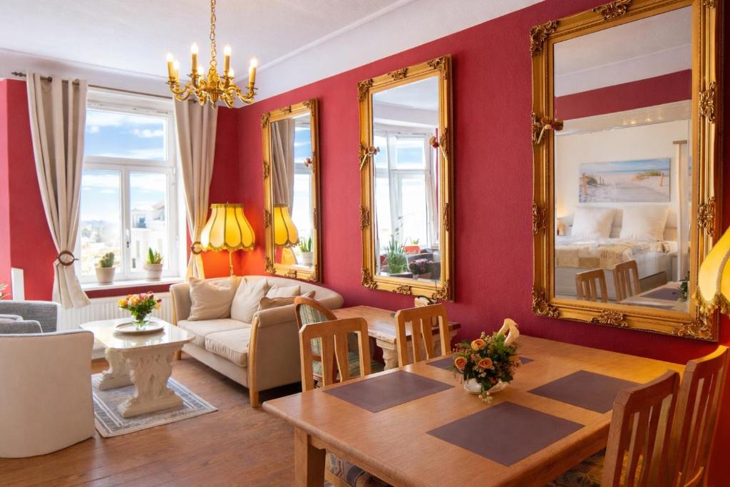 a living room with red walls and a table and mirrors at fewo1846 - Royal Suite - Stilvolle Wohnung mit 2 Schlafzimmern im Stadtzentrum in Flensburg