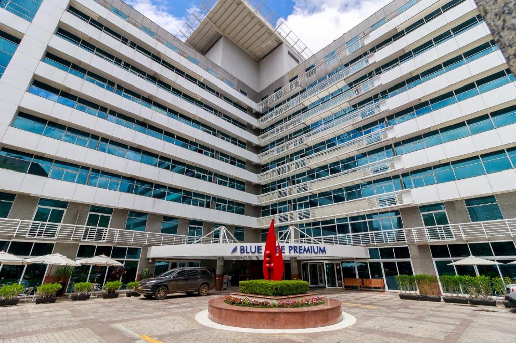 a large building with a red umbrella in front of it at Flat Luxo Verbo Divino 6 in São Paulo