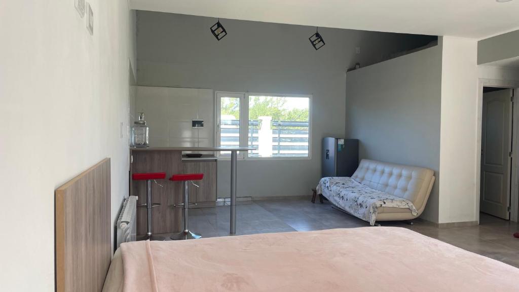 a room with a bed and a kitchen and a table at Mi casa es tu casa Loft in Malargüe