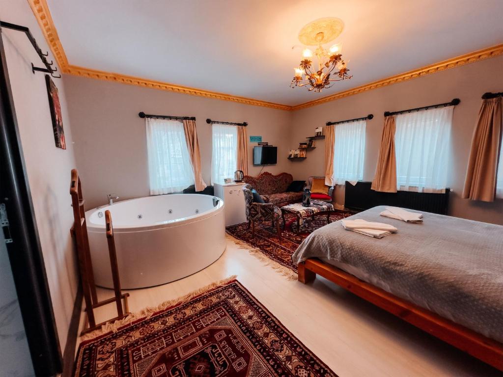 a bedroom with a bath tub and a bed at Alpha Stone House in Göreme